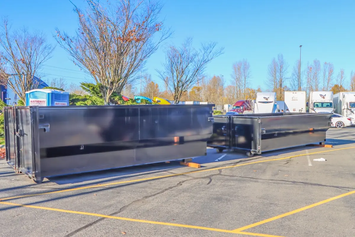 Professional dumpster rental service with roll-off container on residential driveway in East Hampton